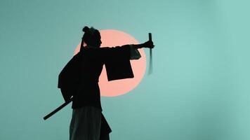 silhouet van een jong Aziatisch vrouw in een traditioneel kimono militant Verwijderen de katana van de schede en maken haar schommel in de studio met een turkoois blauw groen achtergrond en rood zon video