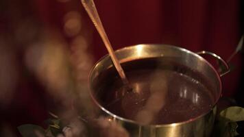 Pot of cocoa and a ladle stands on the table, the drink on the master class video