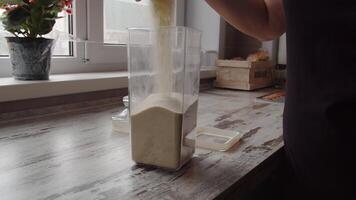 flour is dumped into a storage container close up video