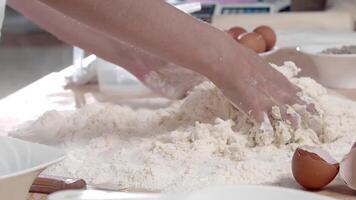 Stirring eggs into a pile of flour on the table video