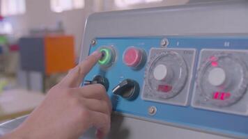 Man's hand presses start button on the control panel of dough machine in the bakery video