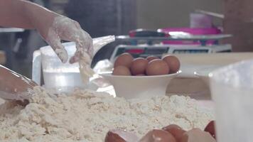 Stirring eggs into a pile of flour on the table video