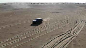 Car is driving in the desert. Dubai, drone camera video