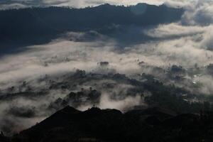 Cloudscape Wonderland, Mountain Peaks Above Clouds, Enchanting Forest Below photo
