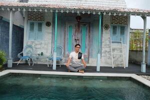 Poolside Serenity, Asian Model in Lotus Yoga Pose, Bali Villa Relaxation photo