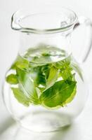 Water with fresh basil in the glass jug photo