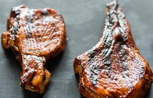 Grilled pork ribs on the wooden background photo
