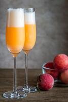 Two bellini cocktails with fresh peaches photo
