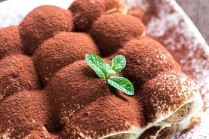 Tiramisu on the plate on the wooden background photo