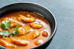 Bowl of thai yellow curry with seafood photo