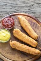 Stack of corn dogs on the wooden board photo