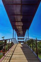 an iron-framed bridge for pedestrians in a park photo