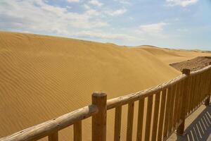 arena dunas detrás un de madera cerca. foto