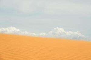 Sand dune in the desert with clouds in the background. photo