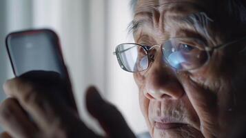 An elderly Asian man has blurred vision from staring at his phone for a long time photo