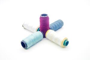 several rolls of colorful sewing thread arranged isolated on white background photo