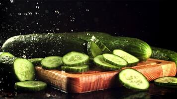 Drops of water fall on the sliced cucumber. On a black background. Filmed is slow motion 1000 fps. High quality FullHD footage video