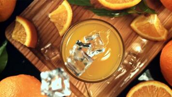 Ice cubes fall into orange juice with splashes. Top view. Filmed is slow motion 1000 frames per second. video