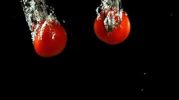 Super schleppend Bewegung Tomaten fallen unter Wasser. . hoch Qualität fullhd Aufnahmen video