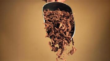 super lento movimento caduta di grattugiato latte cioccolato a partire dal un' notizia in anticipo. girato su un' alta velocità telecamera a 1000 fps. video