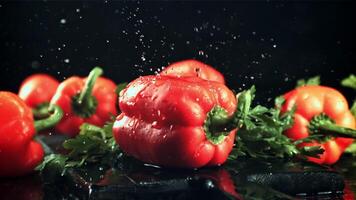 druppels van water met spatten vallen Aan de zoet peper. Aan een zwart achtergrond. gefilmd is langzaam beweging 1000 fps. video