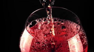 een super langzaam beweging Jet van rood wijn giet in een glas van lucht bubbels. gefilmd Aan een hoge snelheid camera Bij 1000 fps.aan een zwart achtergrond. video
