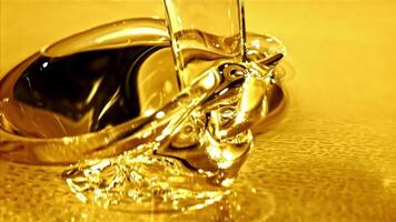 Super slow motion olive oil pours in a stream with splashes. High quality FullHD footage video