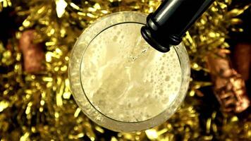 Champagne is poured into a glass with air bubbles. Top view. On a yellow background. Filmed is slow motion 1000 frames per second. High quality FullHD footage video