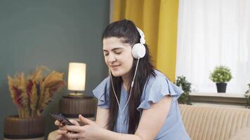 Lycklig kvinna lyssnande till musik med hörlurar. video