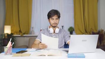 masculino aluna trabalhando entre papel e computador portátil. video