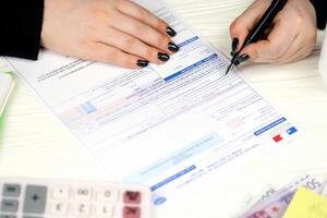 KYIV, UKRAINE - OCTOBER 31, 2023 Accountant fill french tax form 10963 Value added tax and similar taxes in end of tax period. Taxation and paperwork routine photo