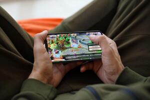 Fantasy Westward Journey mobile iOS game on iPhone 15 smartphone screen in male hands during mobile gameplay photo