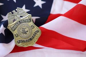 KYIV, UKRAINE - MARCH 9, 2024 US Border Patrol Agent badge on United States of America flag photo