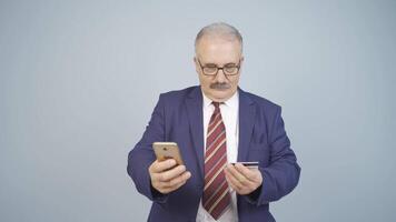 Businessman shopping on the phone with a credit card. video