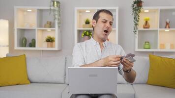 Man looking at laptop counting money. video