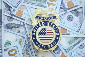 KYIV, UKRAINE - MARCH 9, 2024 US Proud Veteran badge on many US hundred dollar bills photo