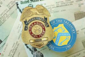 KYIV, UKRAINE - MARCH 9, 2024 US Treasury Police Secret Service Officer badge and Department of Treasury seal on United States Constitution photo