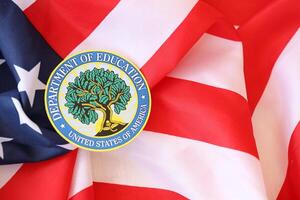KYIV, UKRAINE - MARCH 9, 2024 US Department of Education seal on United States of America flag photo