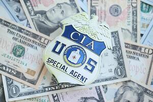 KYIV, UKRAINE - MARCH 9, 2024 US CIA Central Intelligence Agency badge on many US dollar bills photo