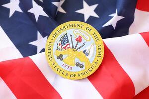 KYIV, UKRAINE - MARCH 9, 2024 US Department of Army seal on United States of America flag photo