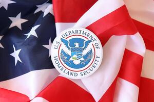 KYIV, UKRAINE - MARCH 9, 2024 US Department of Homeland Security seal on United States of America flag photo