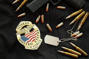 KYIV, UKRAINE - MARCH 9, 2024 US Air Force Veteran badge on black jacket uniform with gun, bullets and dogtags photo