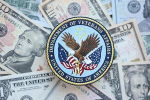 KYIV, UKRAINE - MARCH 9, 2024 US Department of Veteran Affairs seal on many US dollar bills photo