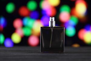 Women fragrance perfume bottle on dark festive background close up. Unnamed blank sprayer bottle of perfume photo