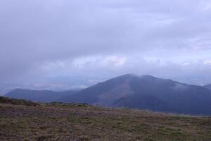 Morning view from the Dragobrat mountain peaks in Carpathian mountains, Ukraine. Cloudy and foggy landscape around Drahobrat Peaks photo