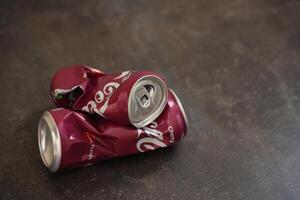 KYIV, UKRAINE - 4 MAY, 2023 Coca cola soft drink crumpled tin can with cherry flavour photo