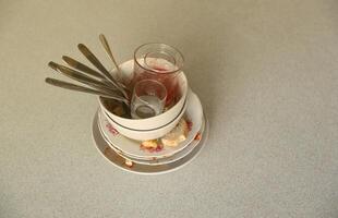 pila de platos sucios con restos de comida en la mesa después de la comida. concepto de final de banquete. platos sin lavar foto