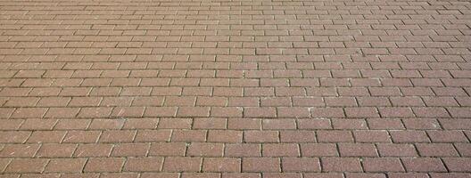 A large area, covered with a quality paving stone in daylight photo