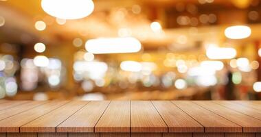 Empty wooden table top with lights bokeh on blur restaurant background. photo