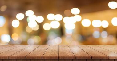 Empty wooden table top with lights bokeh on blur restaurant background. photo